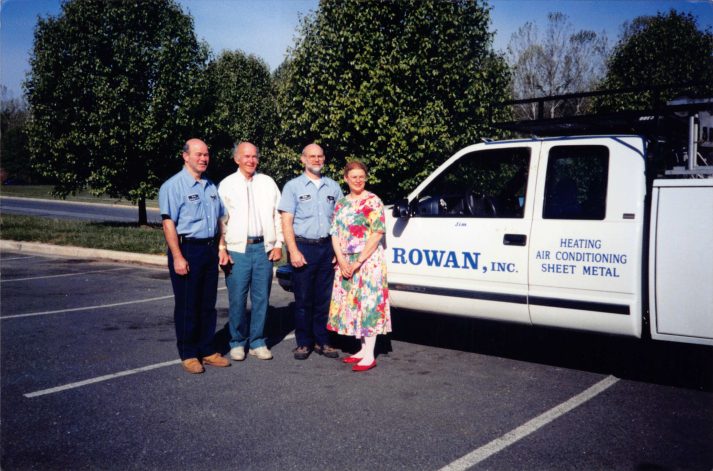 The Rowan team beside one of the original trucks — Heating · Air Conditioning · Sheet Metal.